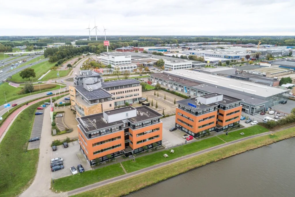 Luchtfoto van kantoren en bedrijfspanden aan de Lage Biezenweg met zicht op een watergang en industrieterrein.